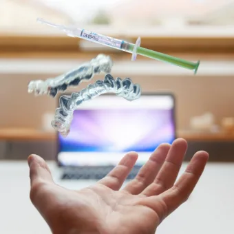 Hand met een beugel en een doseerspuit